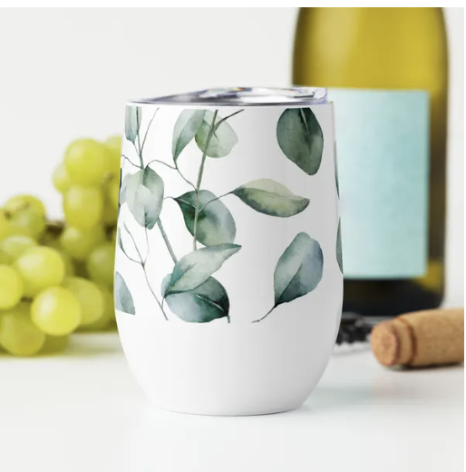 "A beautifully designed tumbler with a watercolor leaf pattern, placed beside grapes and a wine bottle, evoking calm and elegance."